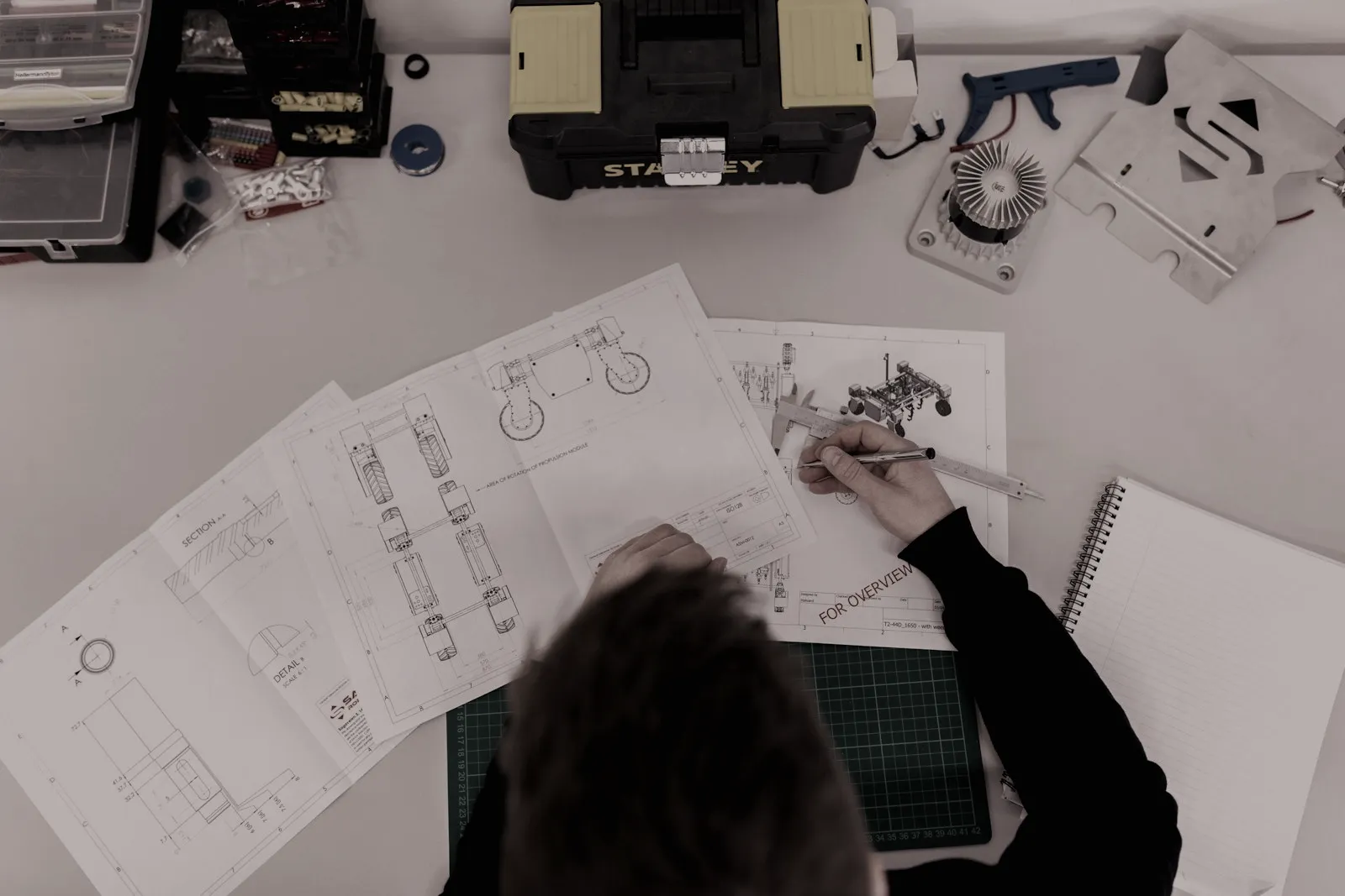 A learner working on technical drawings
